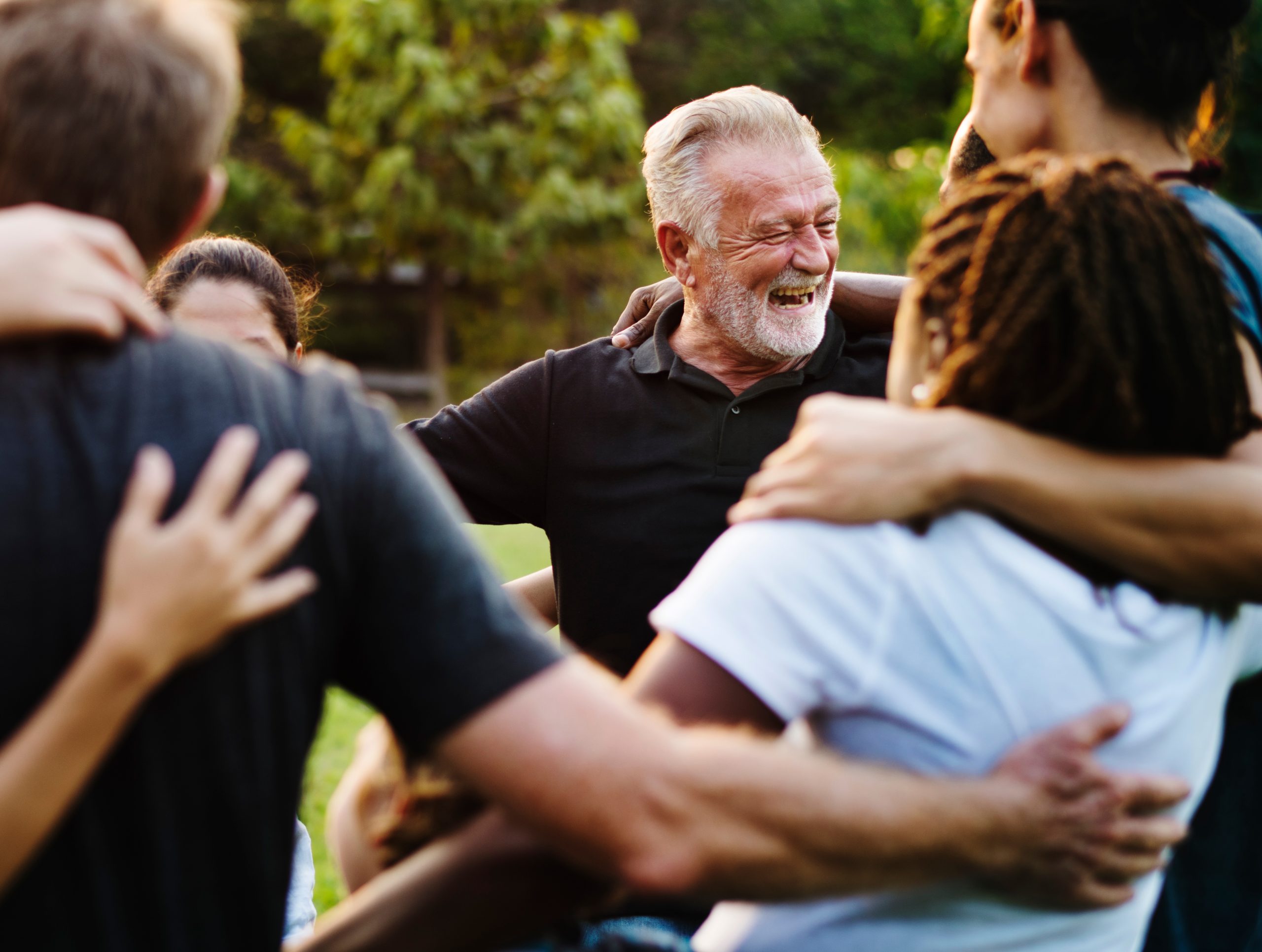 Multi-cultural people hugging standing in a circle