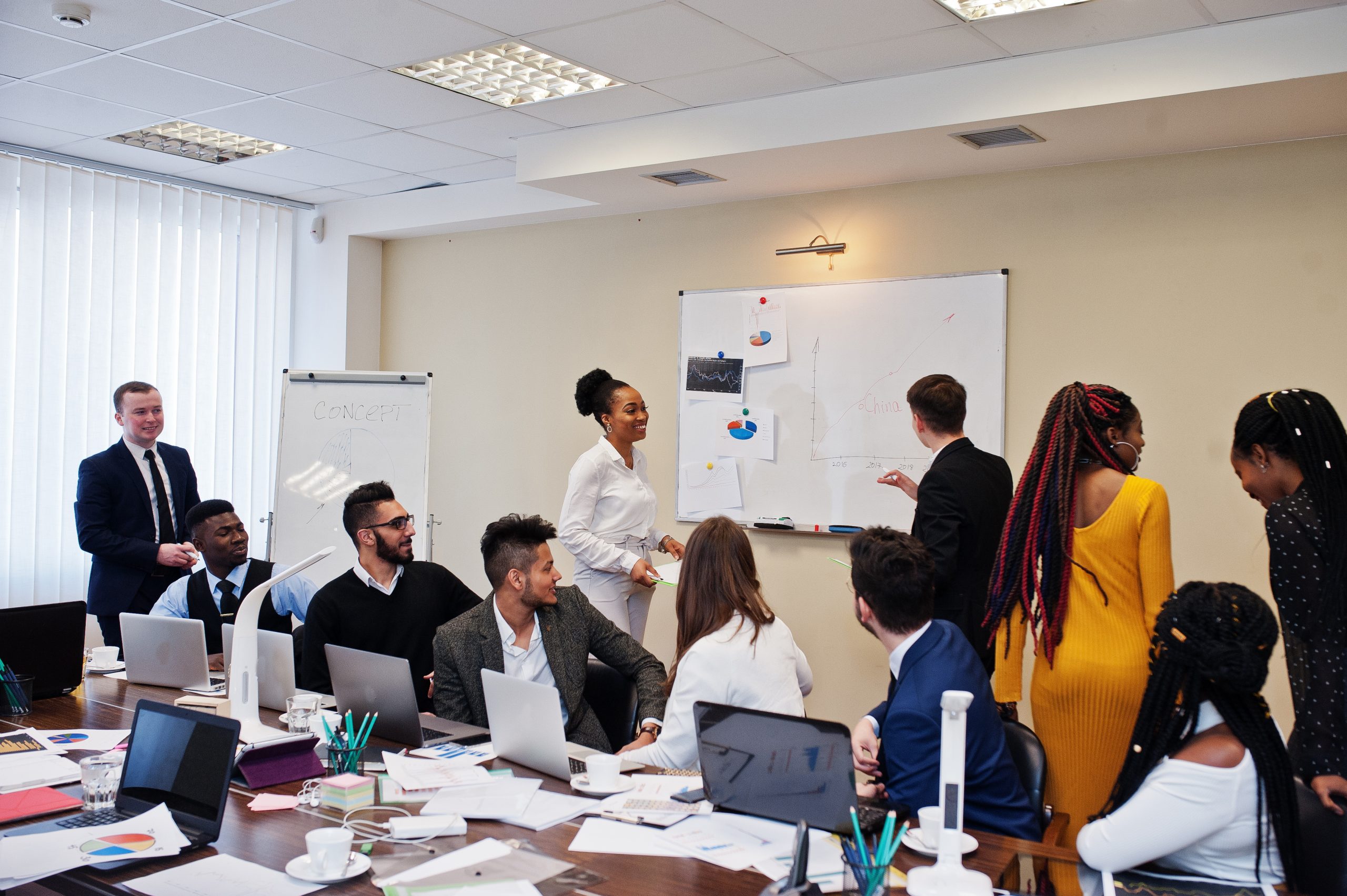 A workshops with some candidates standing by a whiteboard other candidates sitting