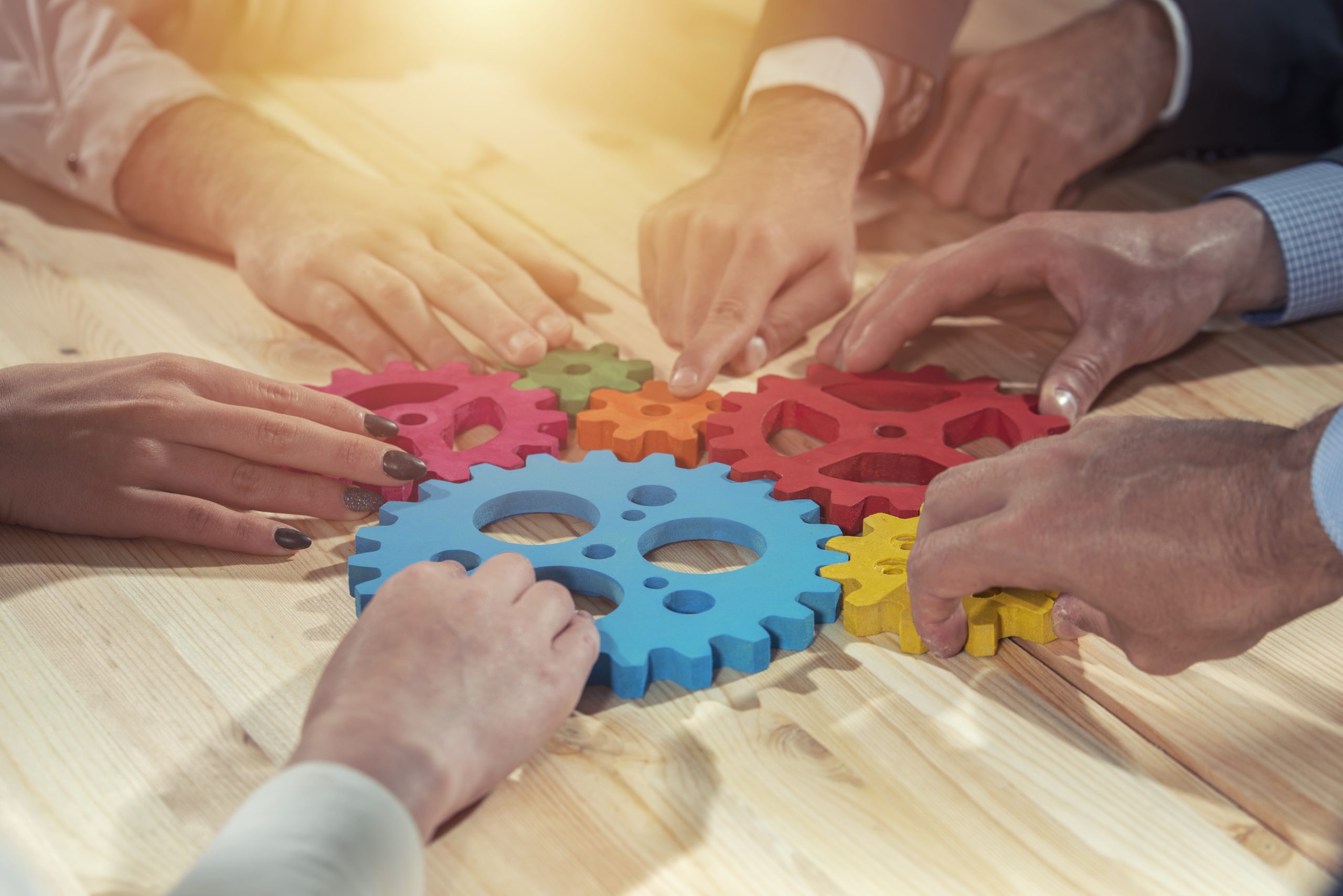Teamwork of businesspeople work together and combine pieces of gears.