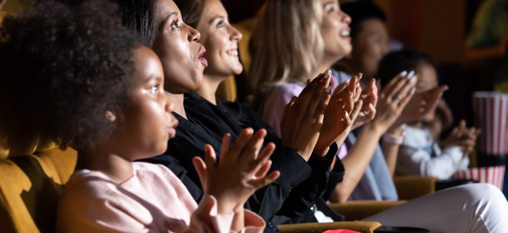 Group of diversity people watching movie in cinema theater with popcorn and drinks. Enjoy Happy laughing fun sad drama action movie concept.