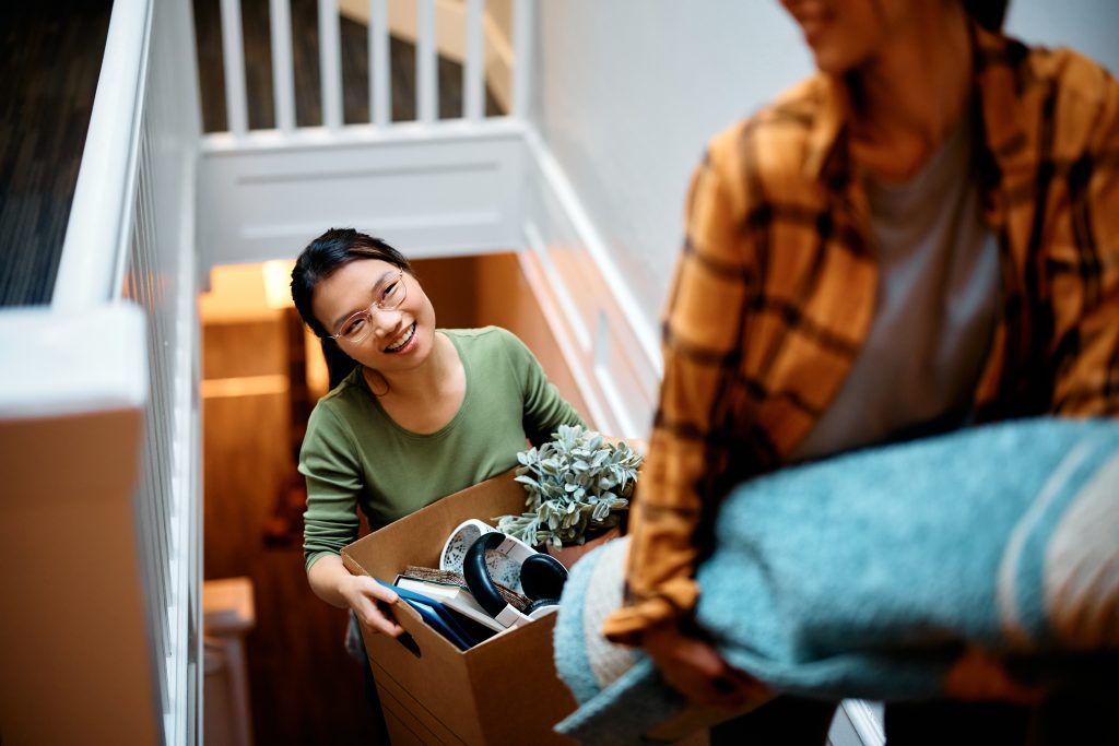 man and woman walking up stairs moving into their accommodation