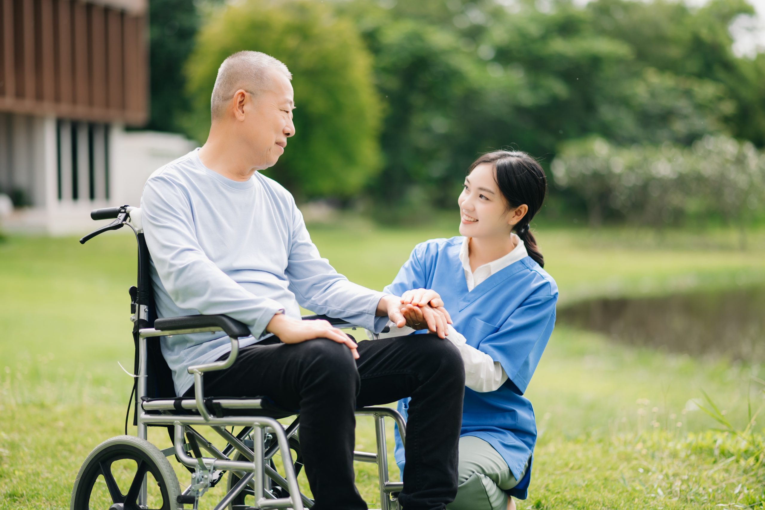 Elderly asian senior man on wheelchair with Asian careful caregiver. 