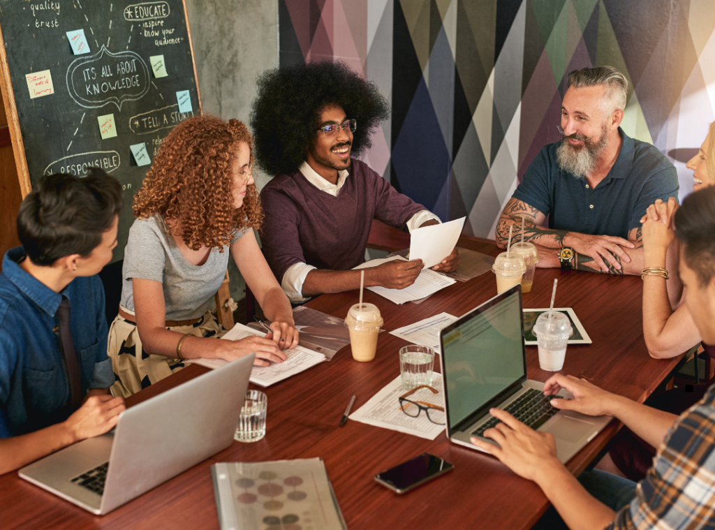 people sitting around the board room table smiling collaborating
