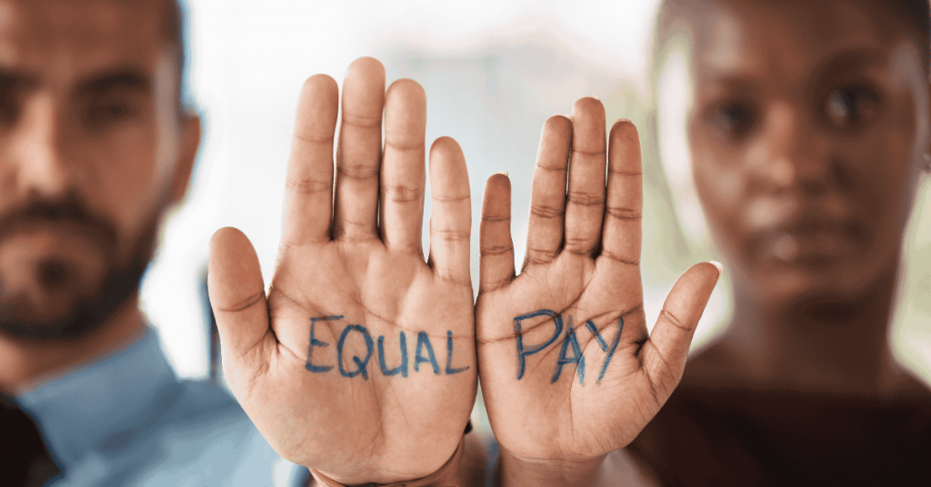 Palms of a man and woman facing outward with Equal Pay written on their palms