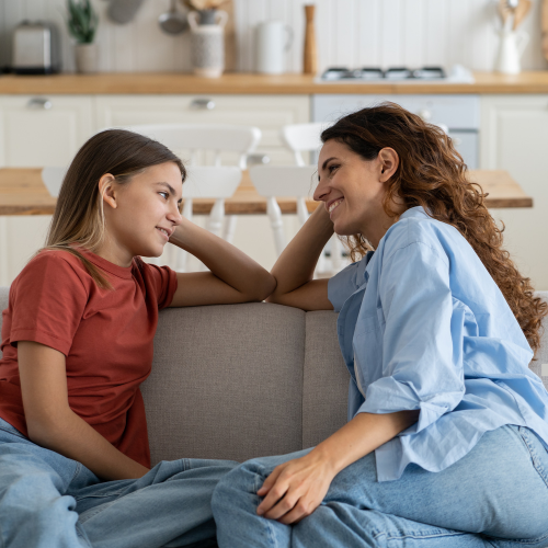 Two ladies sitting on the couch sharing stories