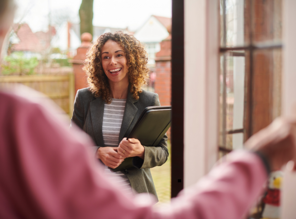 White support worker smiling waiting to come inside