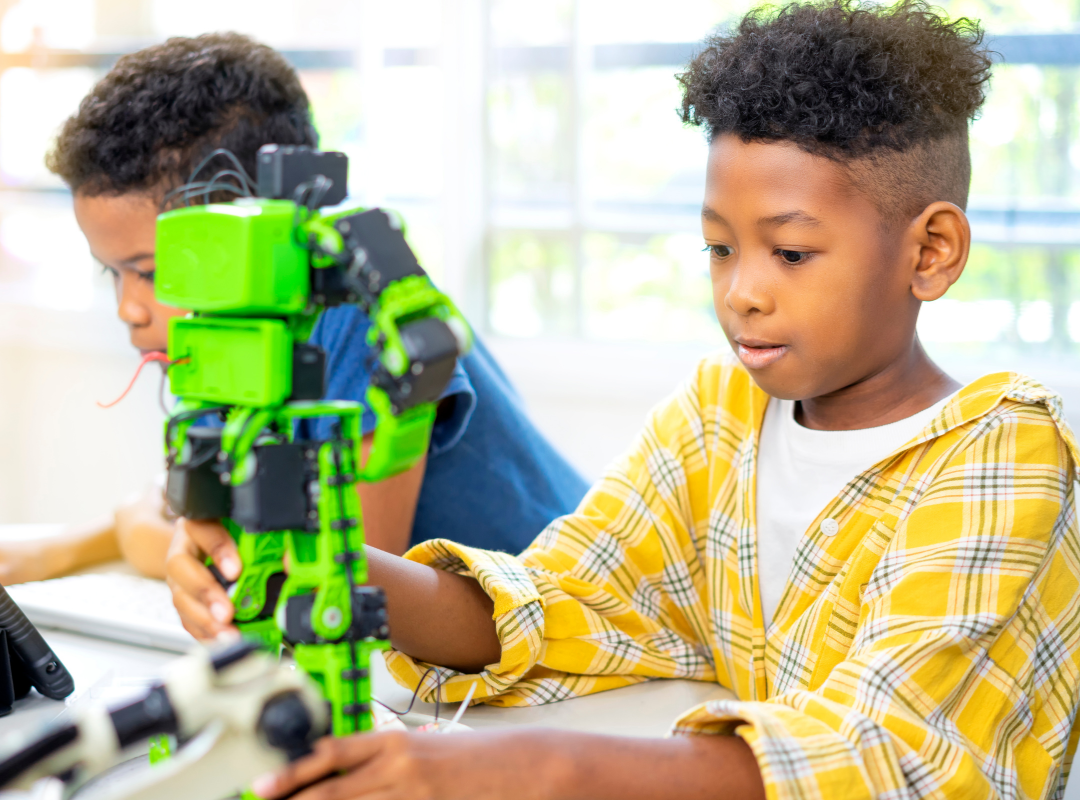 Two black boys one playing with a robot