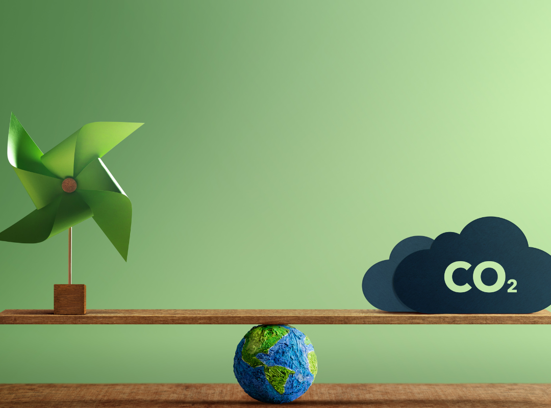 Carbon emission seesaw of a globe holding up a CO2 cloud and a windmill